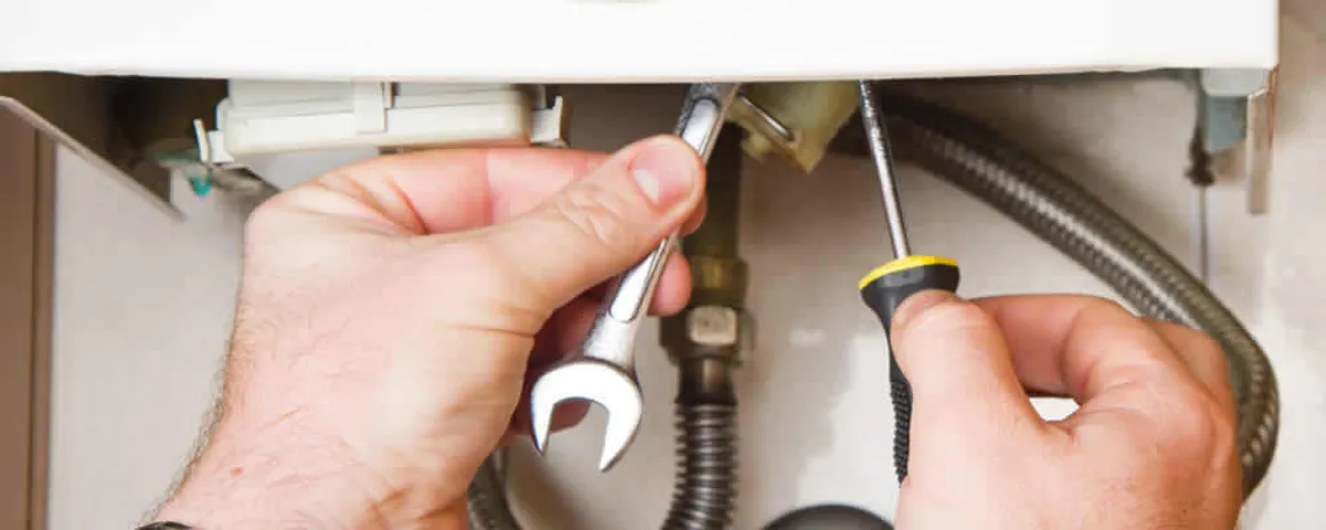 Boiler repair technician tightening pipe fittings and connections in Vancouver, WA