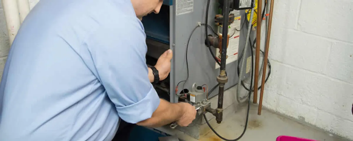 Furnace repair technician inspecting and servicing a home heating system in Vancouver, WA