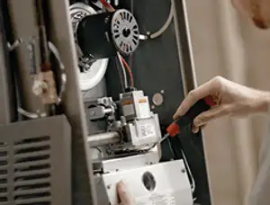Furnace repair technician inspecting internal components and wiring in Vancouver, WA