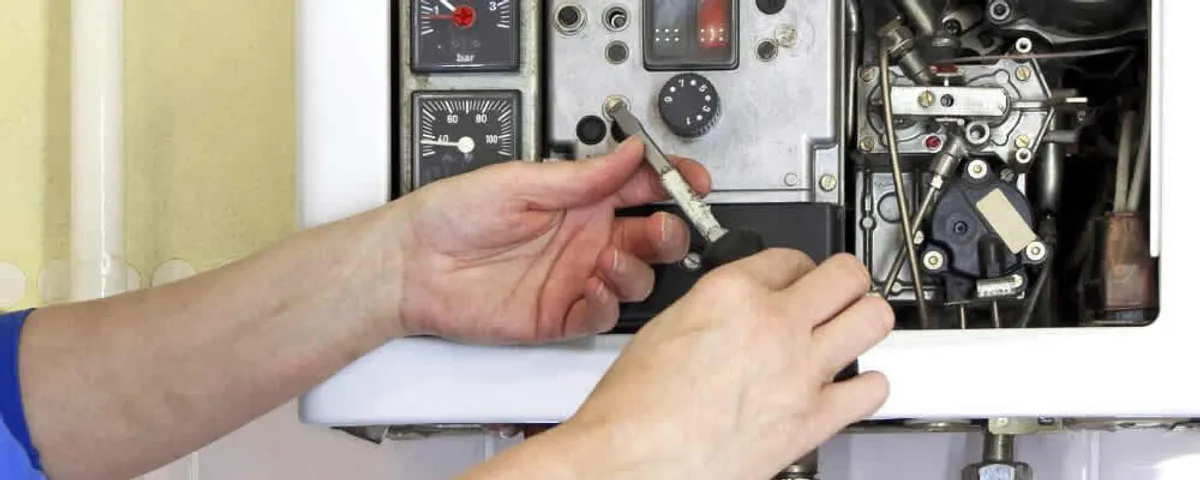 Heating repair technician adjusting boiler controls and components in Vancouver, WA
