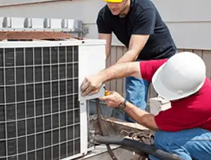 HVAC technicians repairing an outdoor AC unit on a rooftop in Vancouver, WA