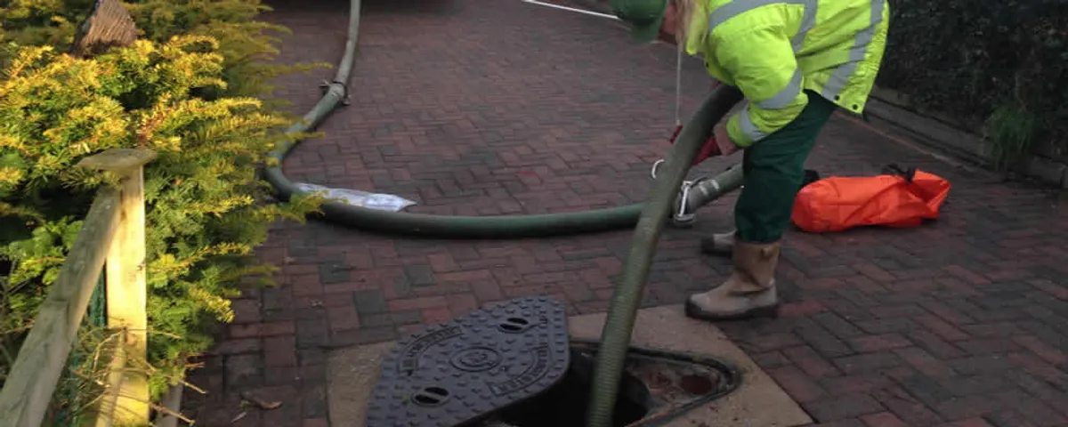 Septic tank cleaning technician servicing a septic tank with a vacuum hose in Vancouver, WA