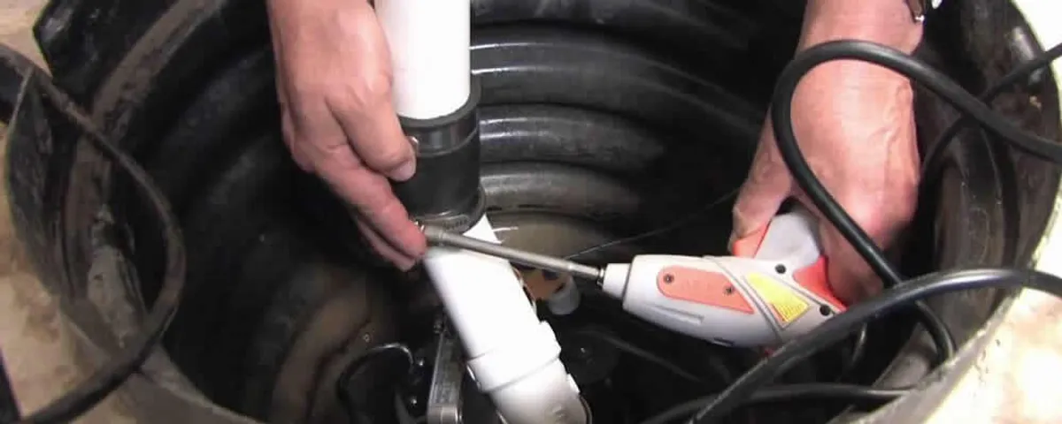 Sump pump installation technician connecting PVC discharge piping in Vancouver, WA